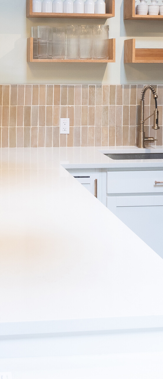 Quartzite countertop with open shelving and tile backsplash
