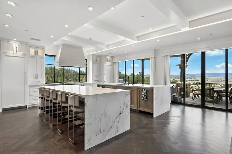 Bianco Superiore quartzite waterfall island with bar seating in an open-concept Castle Pines kitchen