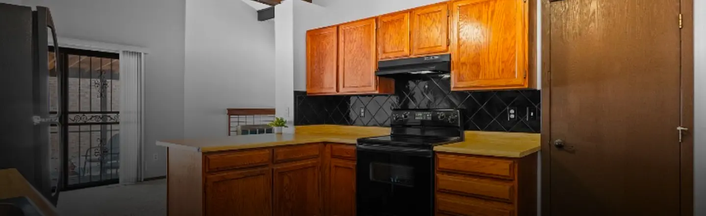 Traditional kitchen with warm oak cabinetry, a dark diamond-pattern tile backsplash and a black range