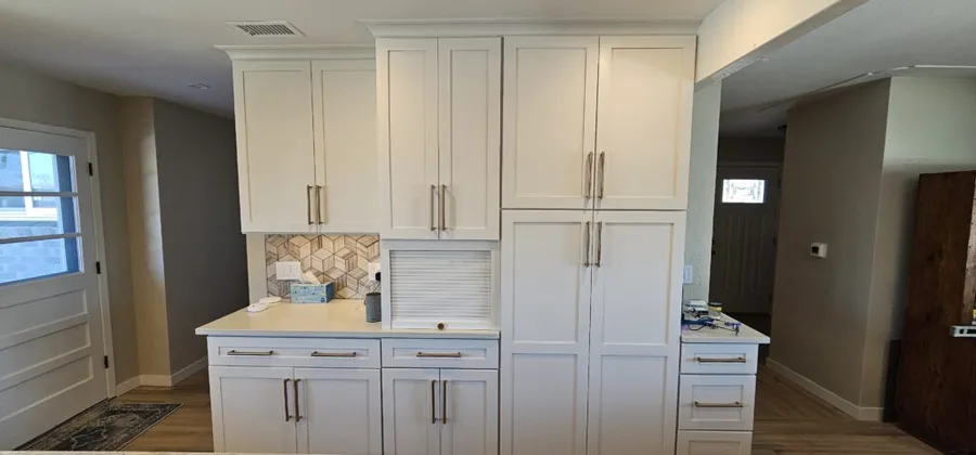 Floor-to-ceiling white pantry cabinetry flanking a kitchen entryway