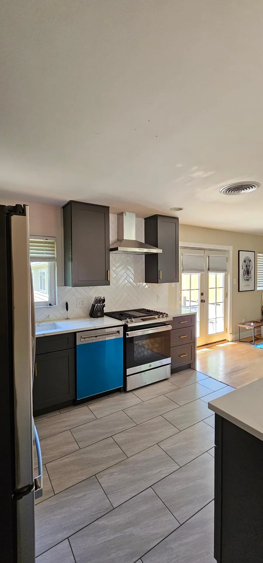 Galley kitchen remodel with dark cabinets, tile flooring and a stainless range