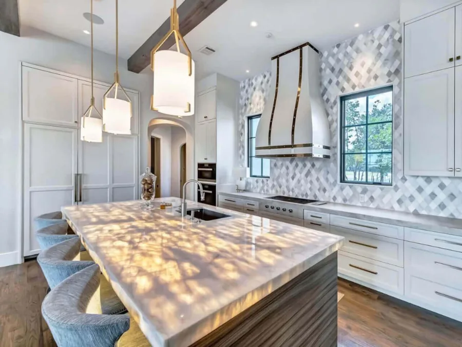 Large quartz island with seating in a luxury white Denver kitchen with pendant lighting