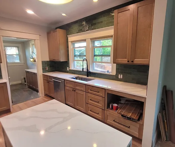 Maple shaker kitchen cabinets with green subway tile backsplash, white quartz countertops, and matching quartz island