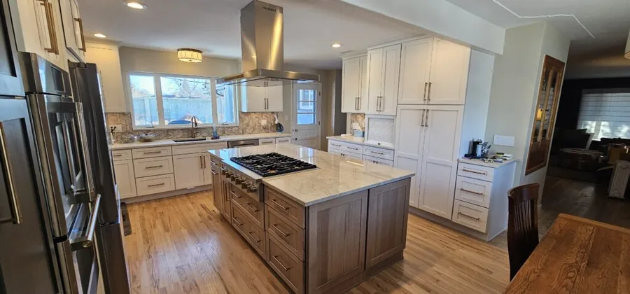 Open kitchen remodel with a stained wood island and white perimeter cabinets