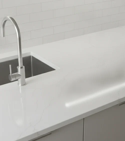 Quartz Countertop Cost in Denver: What to Budget in 2026 Modern kitchen with white quartz countertops, stainless steel sink, and granite backsplash in Denver home