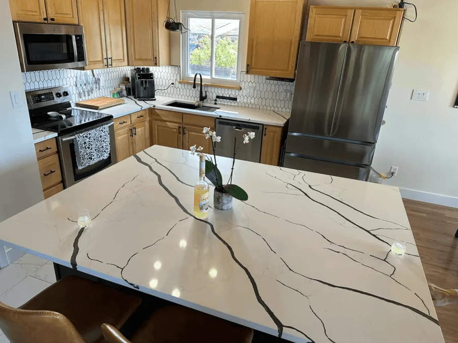 Close view of a veined quartz island countertop with a waterfall edge