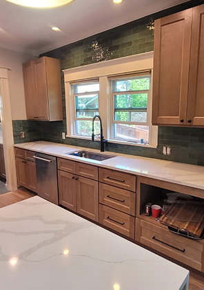 Wood shaker kitchen with a deep green tile backsplash, black gooseneck faucet and a white veined stone countertop